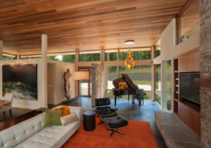 A living room with a couch, chair and piano.