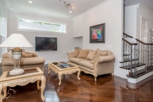 A living room with couches, tables and a television.