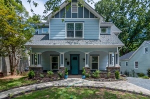 A blue house with a green door and stone walkway.