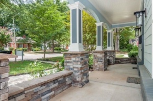 A porch with pillars and stone columns.