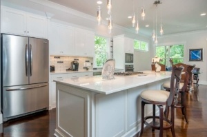 A kitchen with white cabinets and a large island.