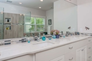 A bathroom with a large mirror and two sinks.
