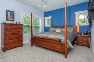 A bedroom with blue walls and four poster bed.