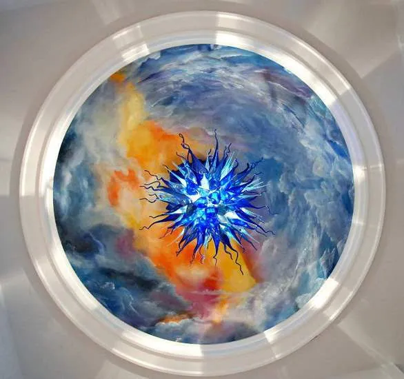 A circular painting of the sky with a blue star in it.