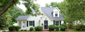 A white house with black shutters and windows.