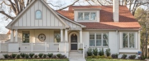 A white house with red roof and front porch.