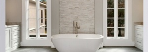 A white bath tub sitting in front of a tiled wall.