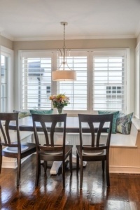 A dining room table with four chairs and a bench.