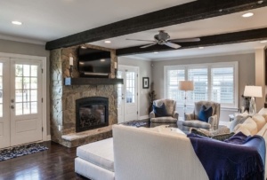 A living room with a fireplace and a large tv.