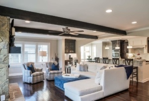 A living room with white furniture and wooden floors.
