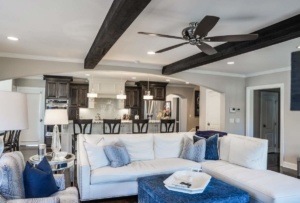 A living room with white furniture and blue pillows.