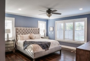A bedroom with a bed, nightstand and window.