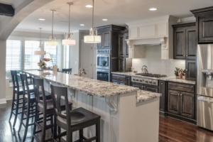 A kitchen with a large island and white cabinets.