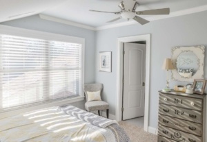A bedroom with a bed, dresser and window.