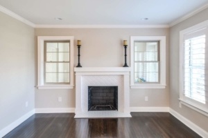 A living room with two windows and a fireplace.