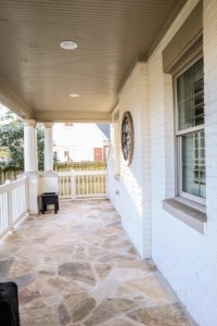 A porch with a clock on the wall.