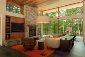 A living room with a fireplace and large windows.