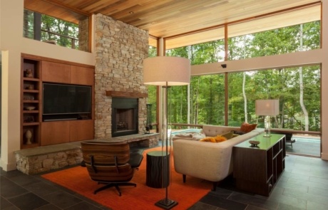 A living room with a fireplace and large windows.