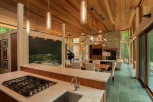 A kitchen with a stove, sink and dining table.