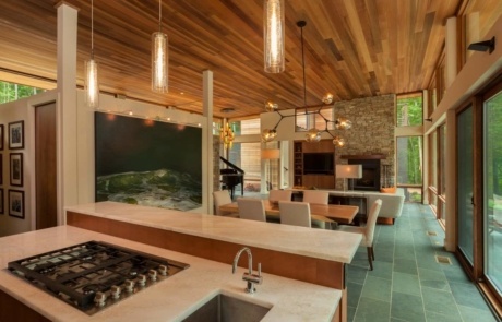 A kitchen with a stove, sink and dining table.