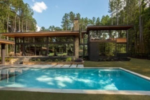 A pool in the middle of a yard with trees.