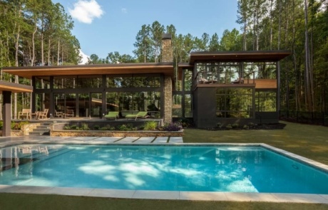 A pool in the middle of a yard with trees.