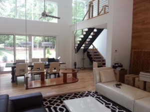 A living room with stairs and a large window.