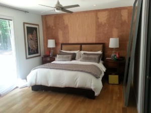 A bedroom with wood paneled walls and a bed.