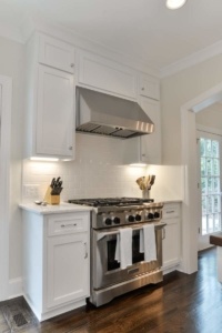 A kitchen with white cabinets and stainless steel appliances.