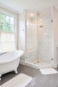 A bathroom with a tub, shower and window.
