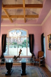 A room with pink walls and a glass table.
