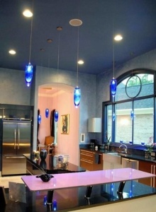 A kitchen with blue lights hanging from the ceiling.