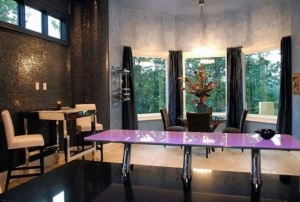 A table in the middle of a room with chairs.