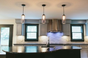 A kitchen with three lights hanging above the island.