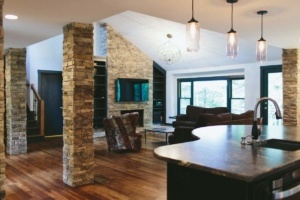 A living room with hard wood floors and stone walls.