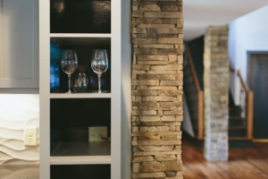 A wine glass and some glasses on the shelf