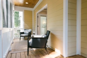 A porch with two chairs and a table.
