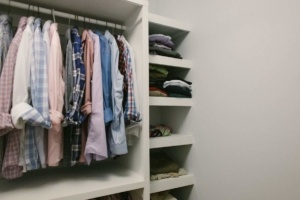 A closet with many shirts hanging on the rail.