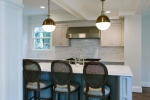 A kitchen with three chairs and two lights
