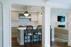 A kitchen with white cabinets and wooden floors.