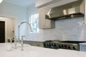 A kitchen with a stove, sink and oven.