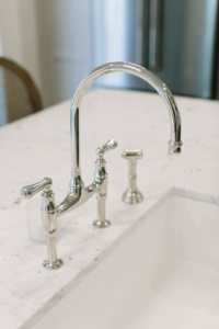 A sink with a faucet and a white counter.