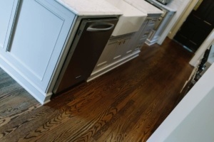 A kitchen with wood floors and white cabinets.