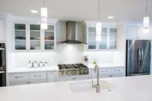 A kitchen with white cabinets and a stove.