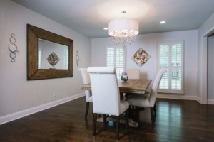A dining room with white chairs and a wooden table.