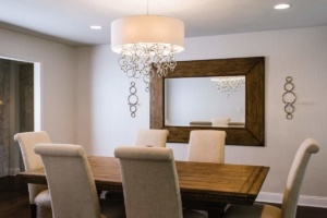 A dining room table with chairs and a mirror