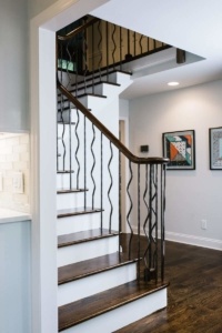 A staircase with metal railing and wood steps.