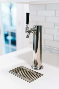 A stainless steel faucet with a metal drip tray.