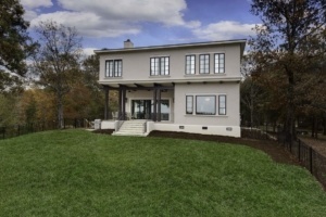 A large white house sitting on top of a green hill.