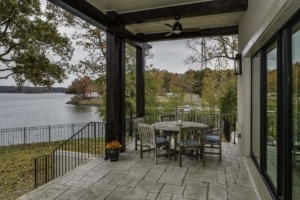 A patio with chairs and table on the side of the house.
